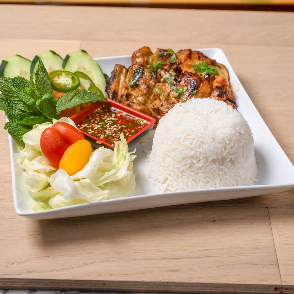 Grilled chicken with rice, fresh mint, cucumber, lettuce, cherry tomatoes, and a chili dipping sauce.