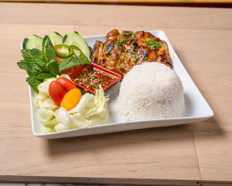 Grilled chicken with rice, fresh mint, cucumber, lettuce, cherry tomatoes, and a chili dipping sauce.